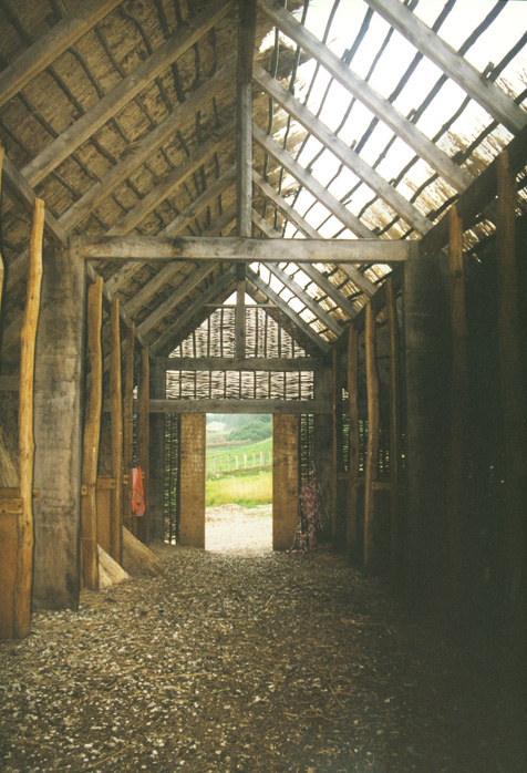 Fyrkat. Interior of long house, showing timber framing and half-thatched roof.